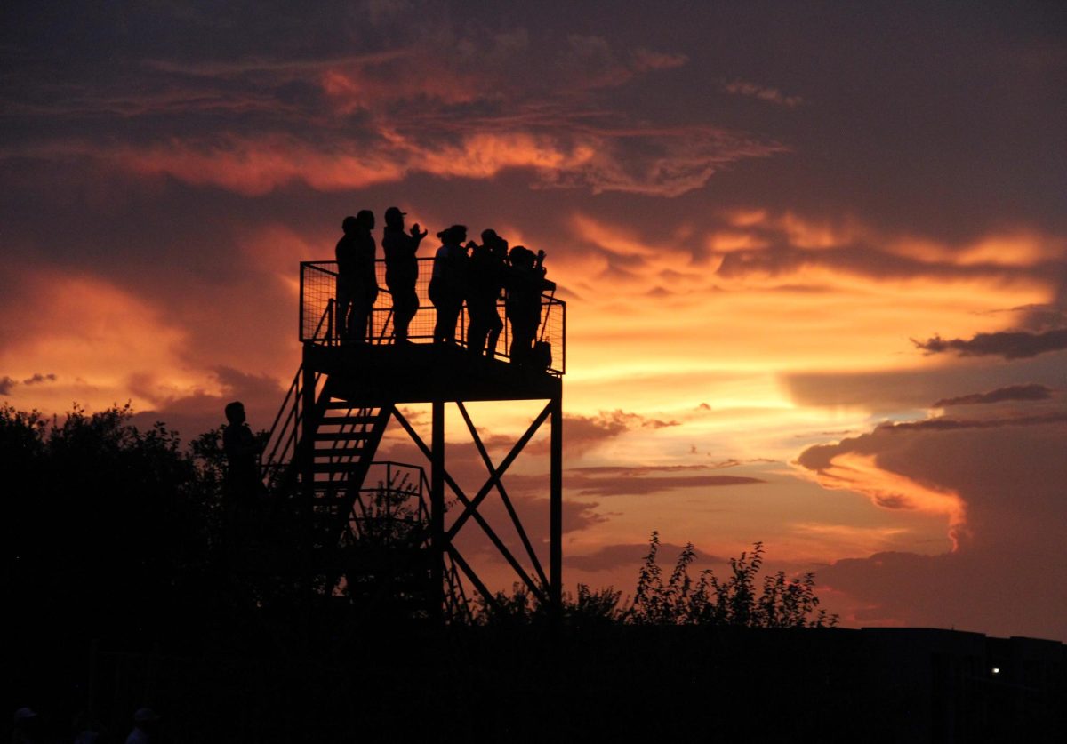 Feature Photo, Superior: FURY ROAD UNDER A FIERY SKY: After an almost hour-long delay due to a threat of lightning, the band began another year of Bandapalooza. Up on the conductors’ podium, Mr. Junkin, the band’s associate director, spoke to the band from up above, surrounded by the evening’s sunset. “Obviously we got a little delayed and so the sun set a little bit earlier than we would have liked, but it’s just a chance for the parents to come out and to see how we go about our rehearsal cause a lot of times they don’t get to see how everything gets done,” he said. “They see the performances on the field but not necessarily how they’re created." Bandapalooza marks the countdown to Taco Shack, the first and biggest football game of the season, just a little under a week away. The band’s preview performed tonight will be put on the big stage at House Park next Thursday.